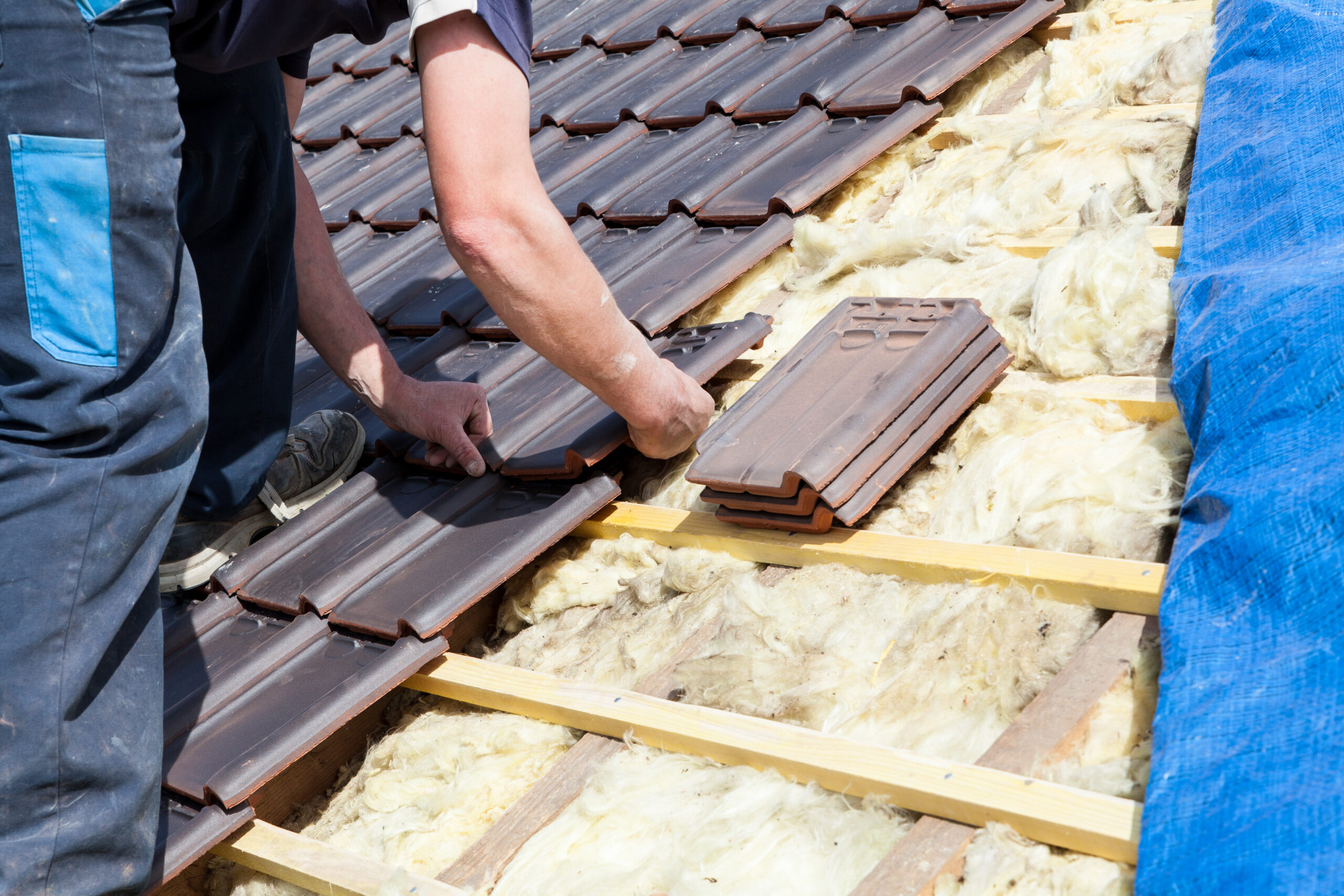 a roofer laying tile on the roof